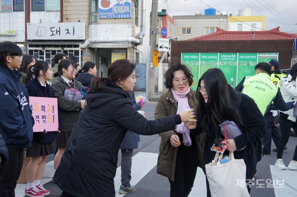 대학수능 응시장에 입장하는 수험생에 따뜻한 차를 건네는 학부모